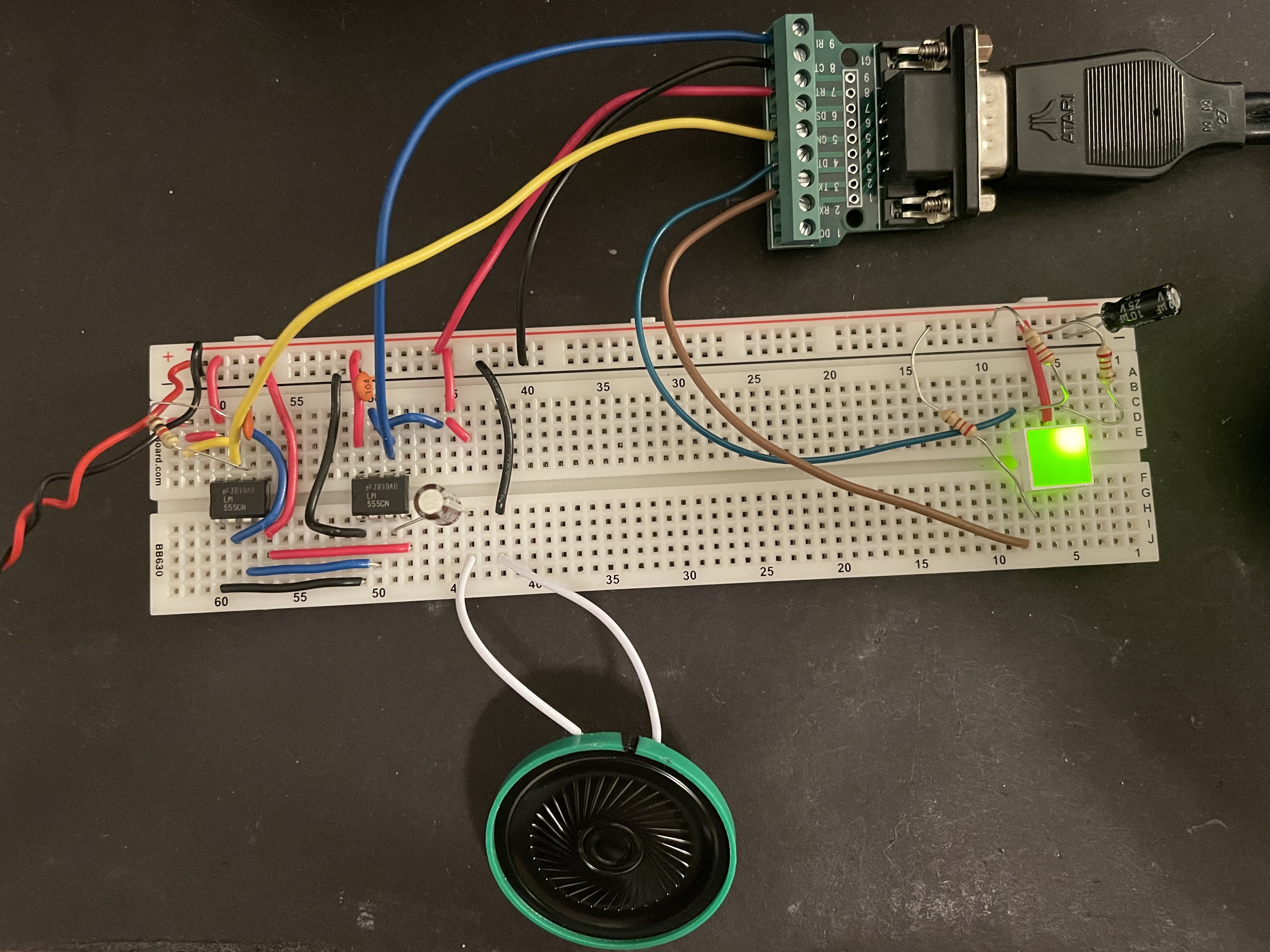 A breadboard with 2 555s, a DE-9 breakout board, and some passive components